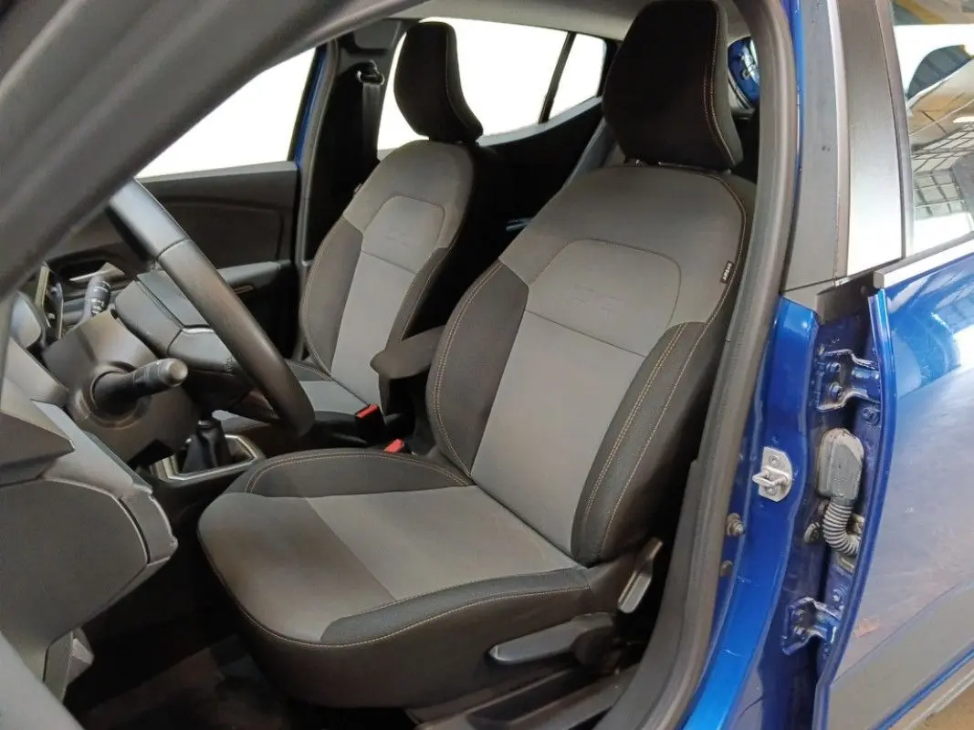 Vue intérieure côté conducteur de la Dacia Sandero Stepway 2025 bleu iron, montrant les sièges et le volant.