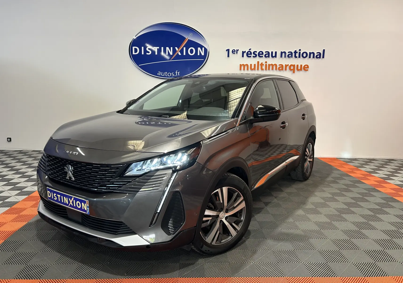 Peugeot 3008 gris Platinium en 3/4 avant droit, avec phares LED allumés et jantes alliage visibles.