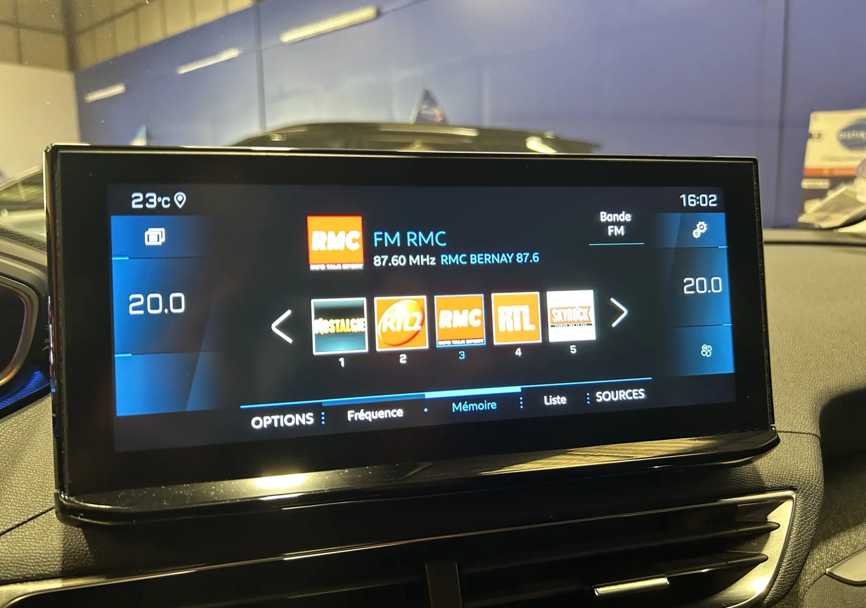 Écran tactile central du Peugeot 3008 II Ph.2 affichant la radio FM avec plusieurs stations et la température intérieure à 20°C.