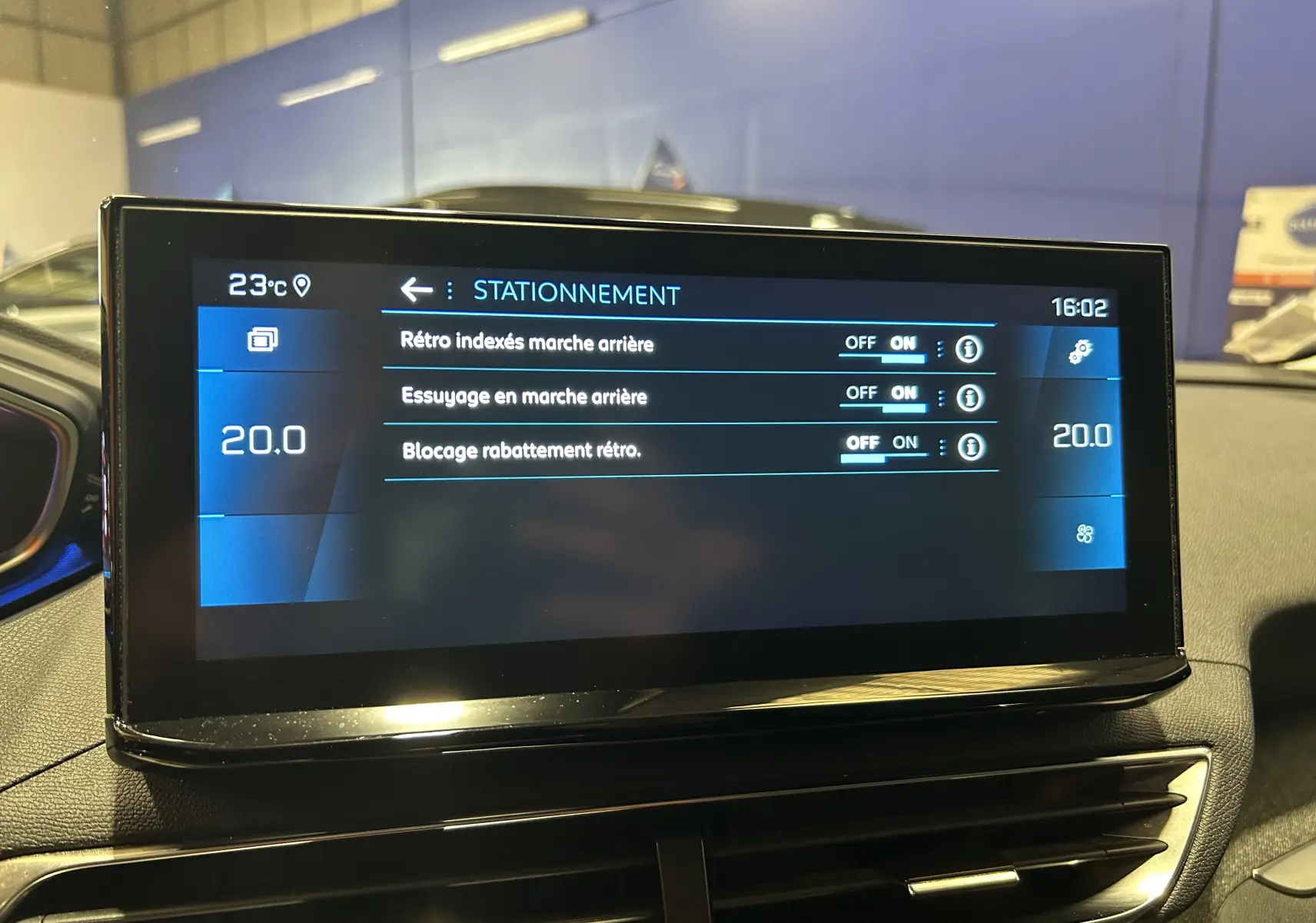 Écran tactile central du Peugeot 3008 II Ph.2, affichant les réglages de stationnement avec interface moderne et éclairage intérieur.