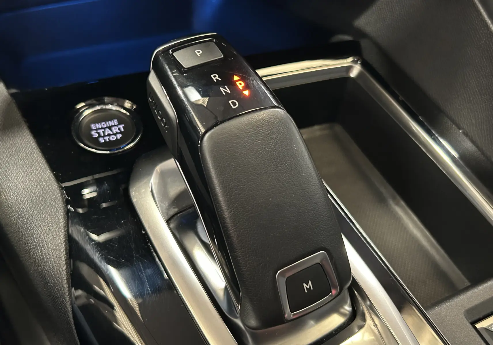 Gros plan sur le levier de vitesses automatique noir et argenté du Peugeot 3008 II Ph.2, avec bouton start/stop visible.
