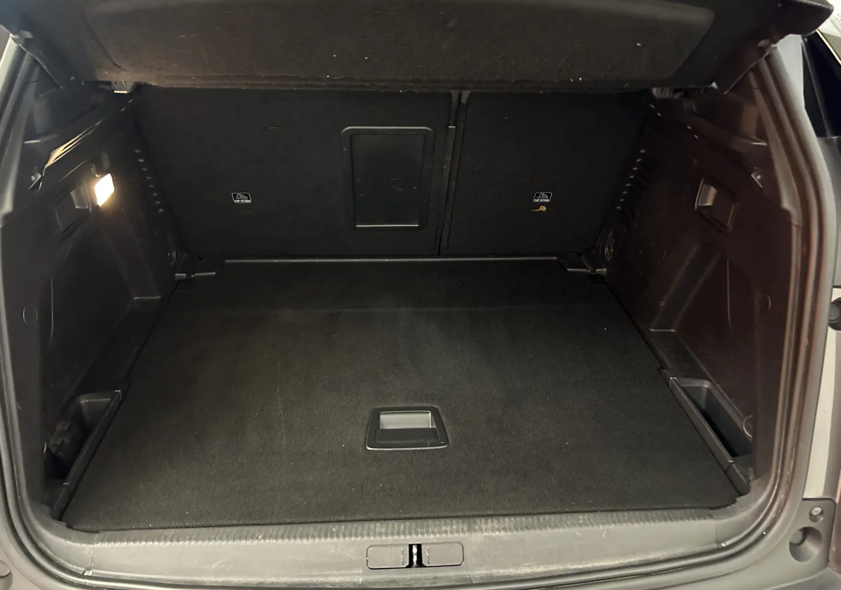 Coffre ouvert en vue arrière d'un Peugeot 3008 gris Platinium, espace de chargement propre et vide.