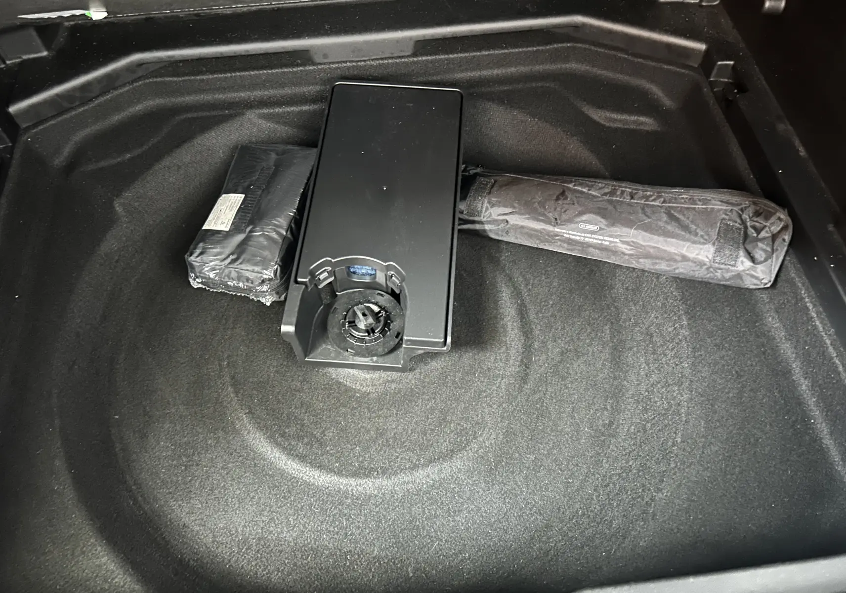 Coffre ouvert d’un Peugeot 3008 gris Platinium, vue plongeante sur espace de rangement avec accessoires rangés.