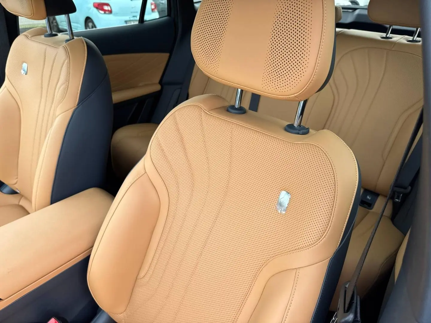 Gros plan sur les sièges avant en cuir beige perforé avec surpiqûres, intérieur du Geely STARRAY 2026.