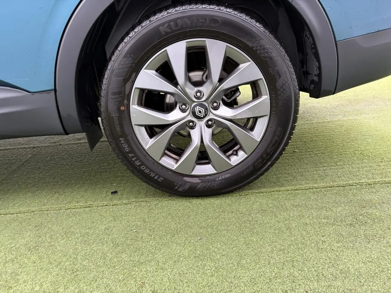 Gros plan sur la roue avant droite avec jante alliage grise du Renault Arkana Bleu Zanzibar 2025.