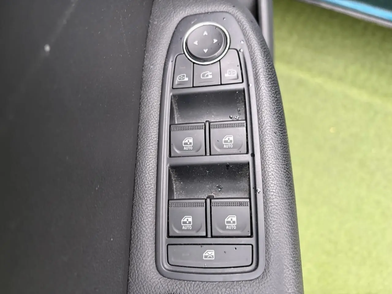 Gros plan sur les commandes des vitres électriques et rétroviseurs sur la porte côté gauche d'une Renault Arkana 2025.