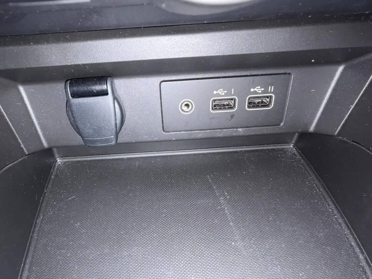 Gros plan sur la console centrale avec prises USB et prise jack du Renault Arkana 2025 en intérieur noir.