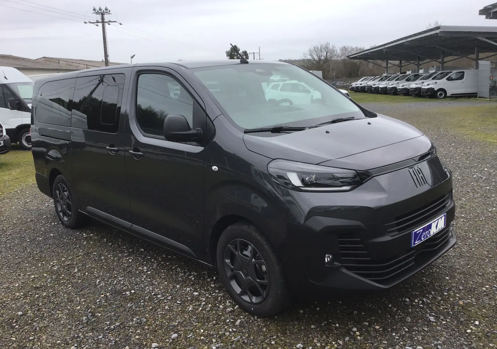 Vue 3/4 avant gauche d’un FIAT Scudo Combi gris titane avec vitres latérales surteintées et jantes noires.