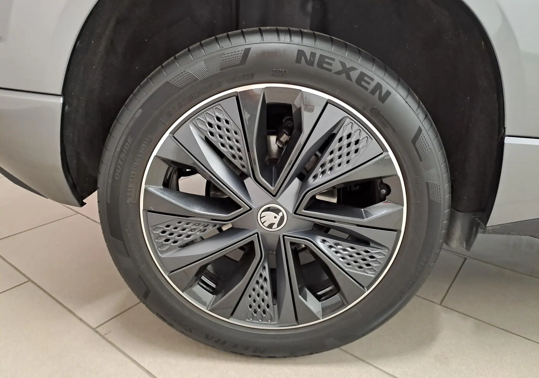 Gros plan sur la roue avant droite du Skoda Karoq gris graphite, mettant en valeur la jante au design moderne.