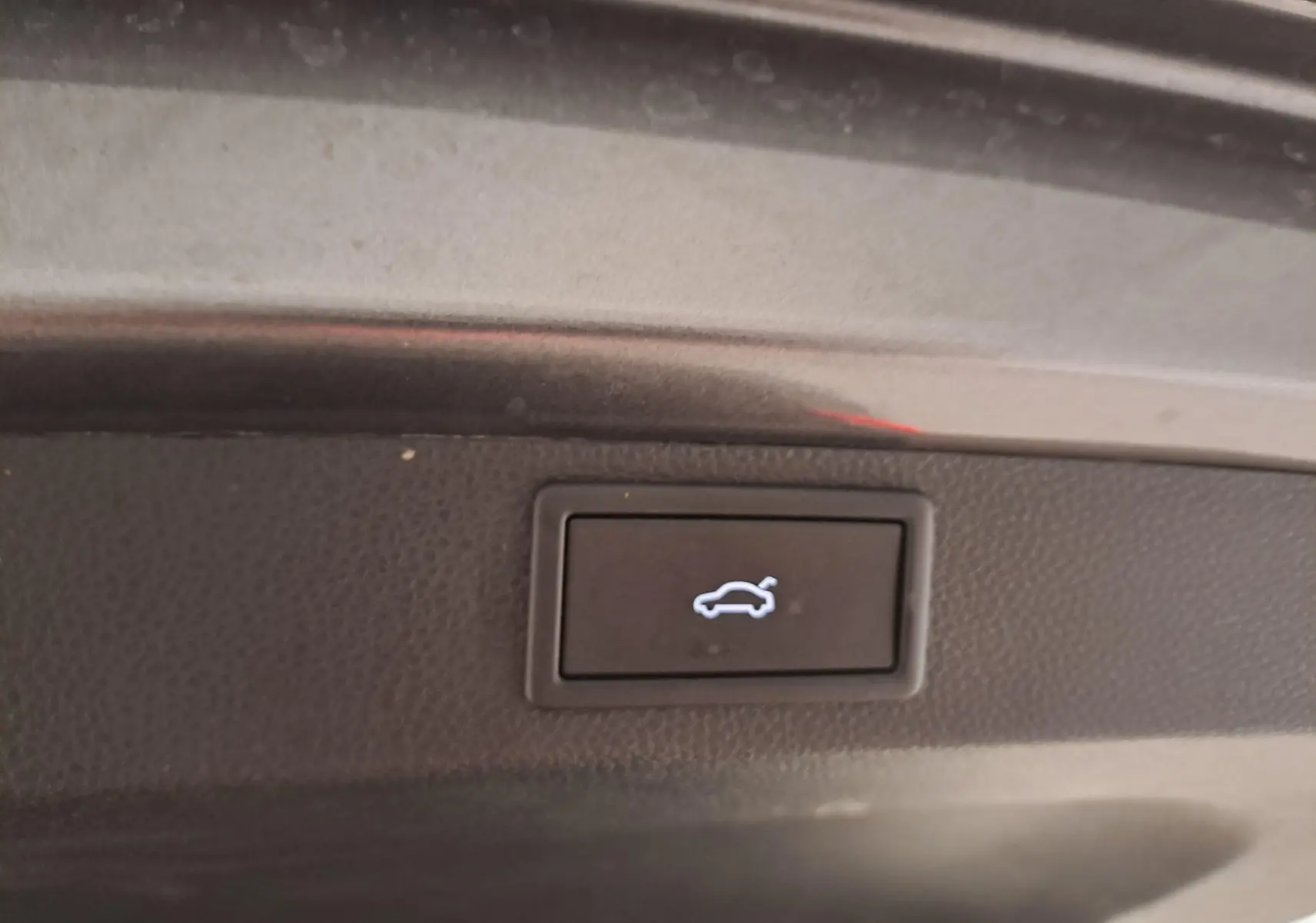 Bouton d'ouverture électrique du hayon sur le coffre d'un Skoda Karoq gris graphite, version 2025.