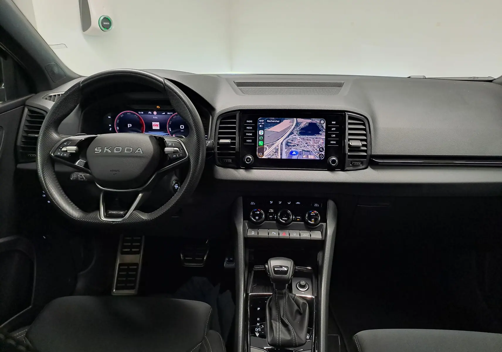 Vue intérieure frontale du tableau de bord du Skoda Karoq gris graphite avec écran tactile et volant multifonction.