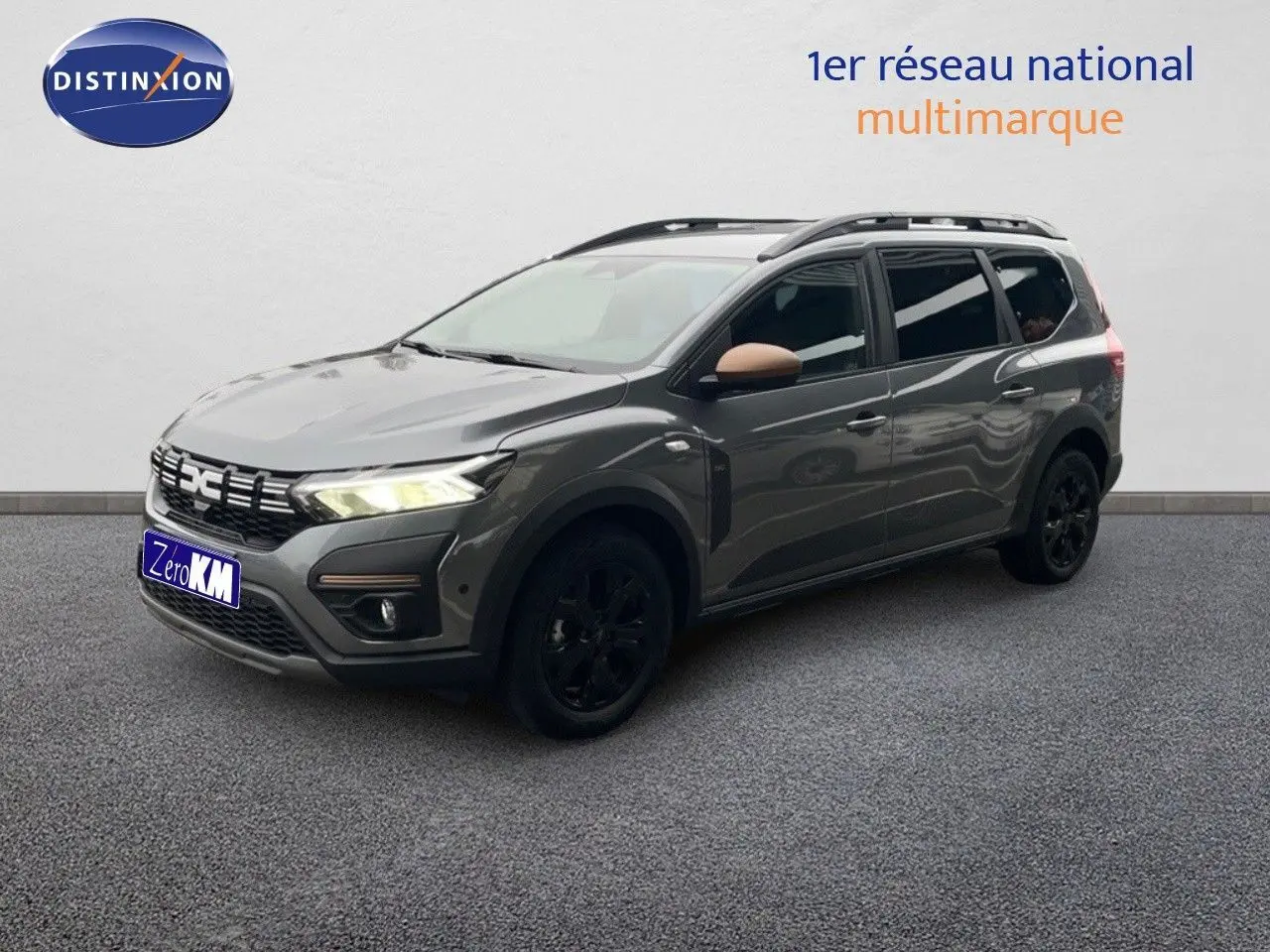 Vue 3/4 avant droit d'un Dacia Jogger gris schiste métallisé avec jantes noires et rétroviseurs couleur bronze.