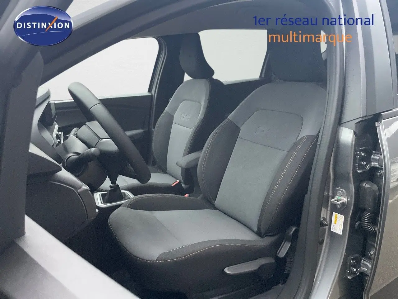 Vue intérieure côté conducteur du Dacia Jogger gris schiste métal, mettant en valeur les sièges en tissu et alcantara avec volant multifonction.