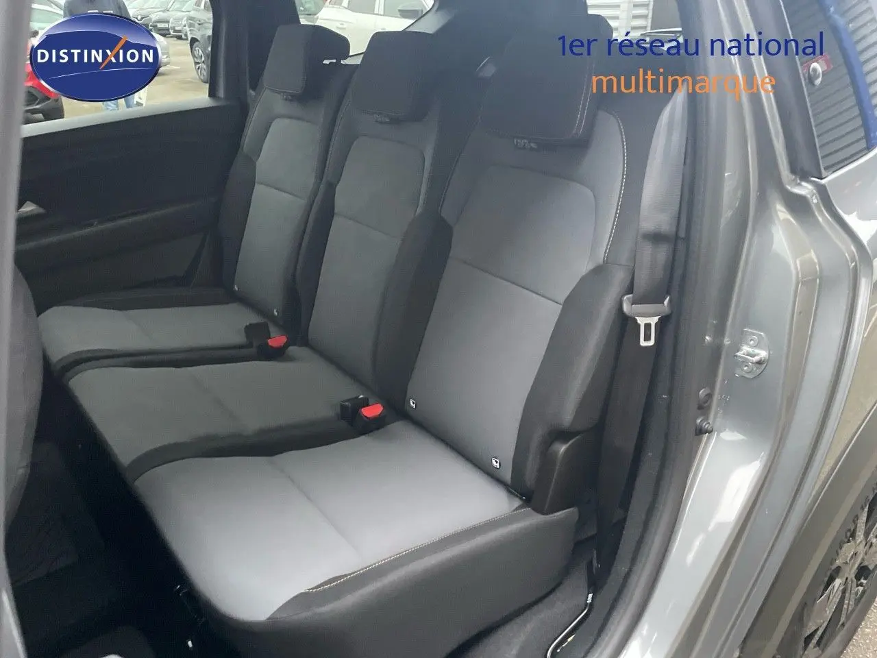 Vue latérale des sièges arrière gris foncé et clair du Dacia Jogger 2026, porte arrière ouverte, intérieur spacieux visible.