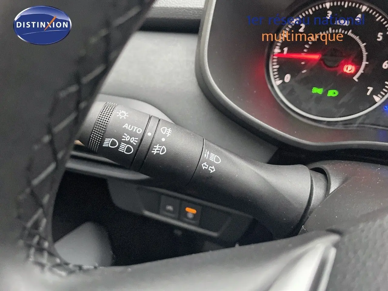 Gros plan sur la manette de clignotants et phares du tableau de bord d’un Dacia Jogger gris schiste métal.