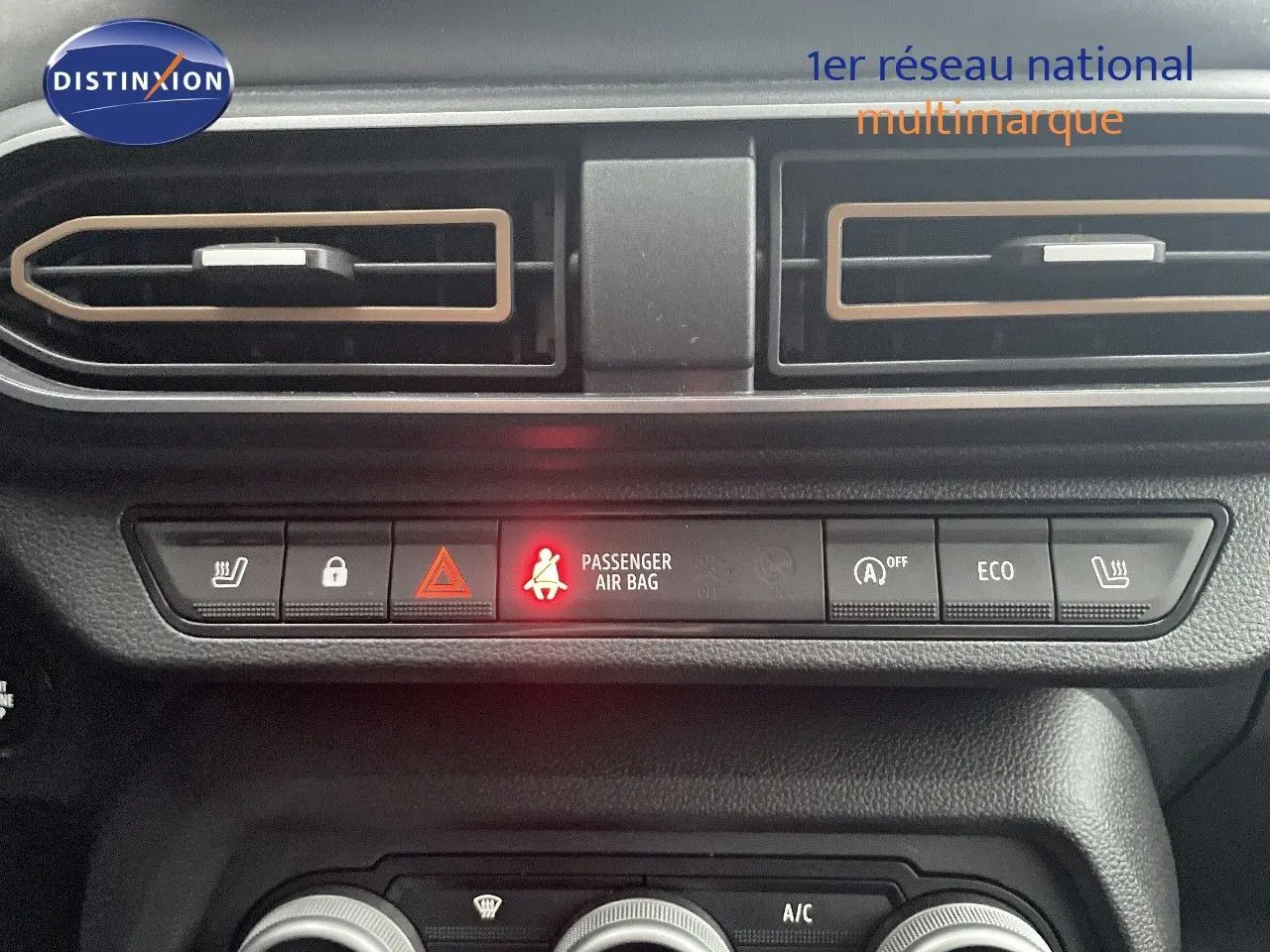 Détail du tableau de bord du Dacia Jogger gris schiste, montrant les commandes de climatisation et les voyants de sécurité.
