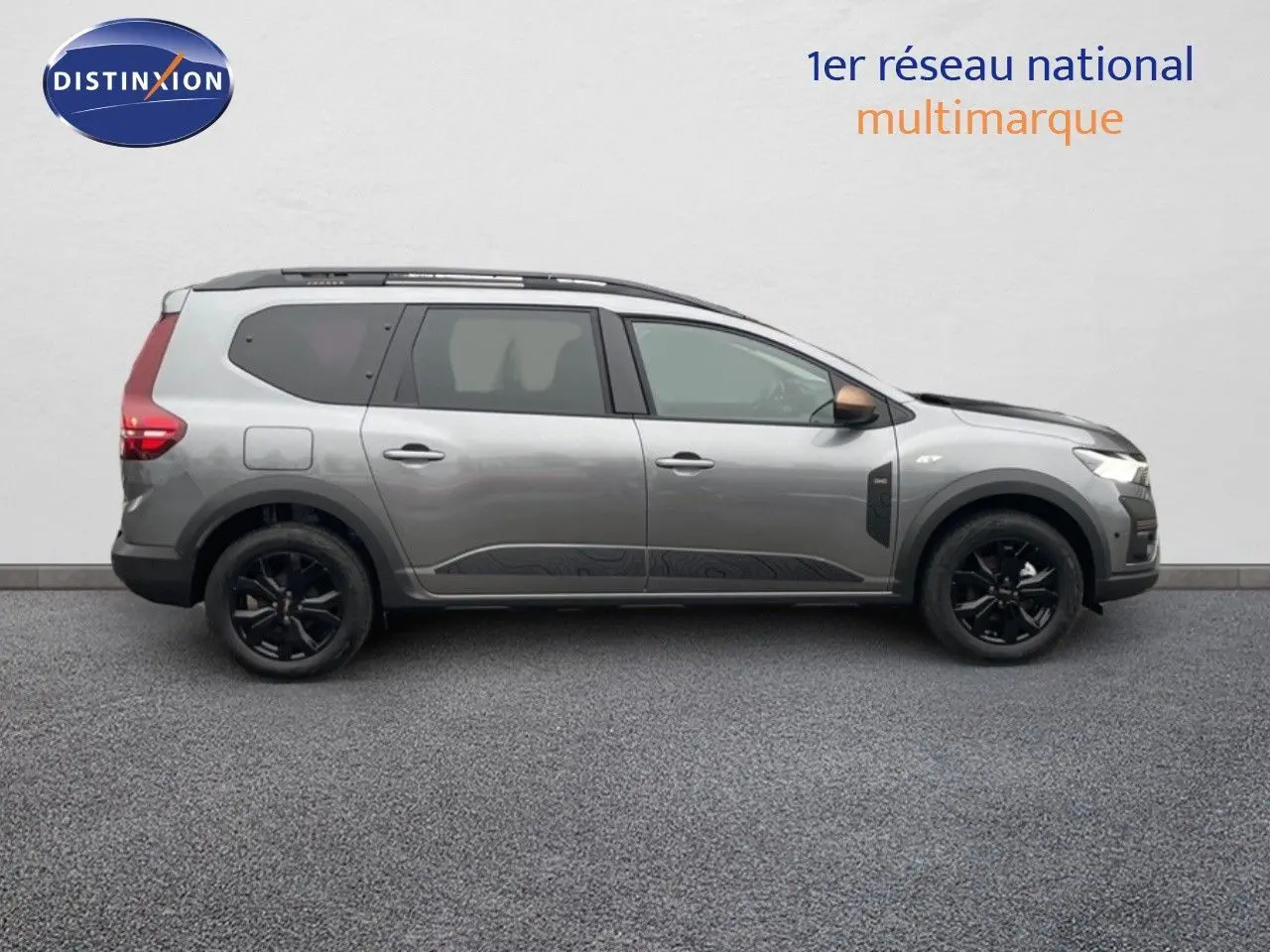 Profil droit d'un Dacia Jogger gris schiste métal 2026 avec jantes noires et détails noirs sur les ailes avant.