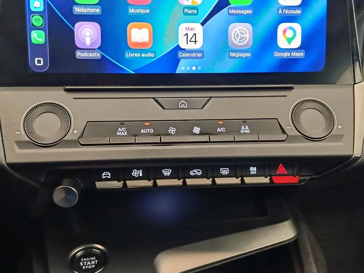 Vue rapprochée du tableau de bord central de la Peugeot 308 2023, avec écran tactile et commandes climatisation digitales.