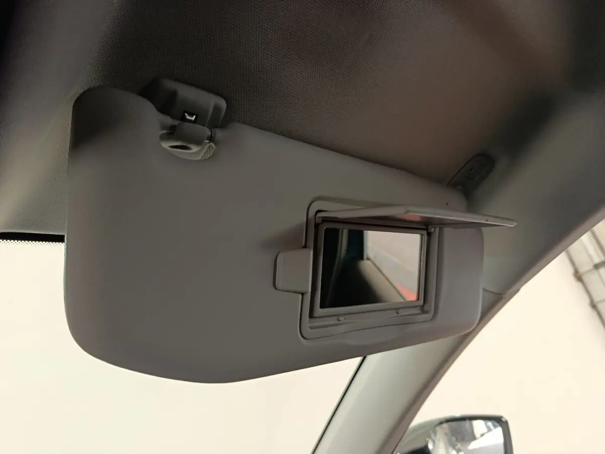 Détail intérieur du pare-soleil gris clair avec miroir de courtoisie ouvert dans une Peugeot 308 2023.