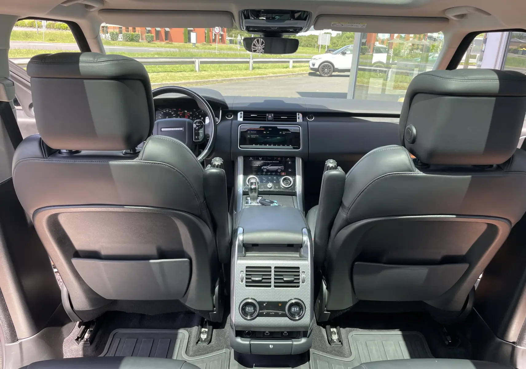 Vue intérieure arrière du Range Rover Sport HSE Dynamic avec sellerie cuir noir et toit panoramique visible.