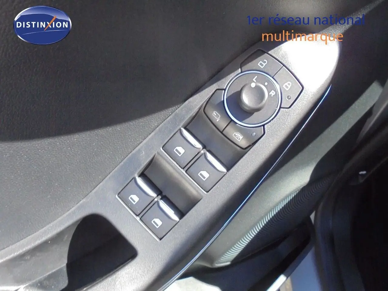 Gros plan sur les commandes des vitres et rétroviseurs côté conducteur d'une Ford Puma gris Solar Metal.