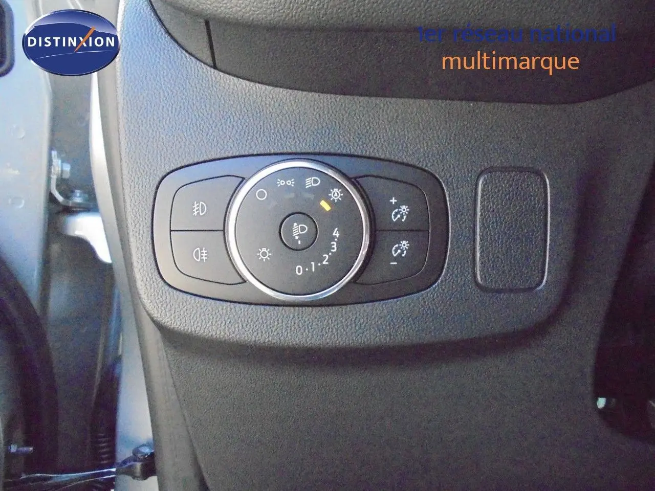 Gros plan sur le panneau de commande des phares à gauche du volant dans une Ford Puma gris Solar Metal 2022.