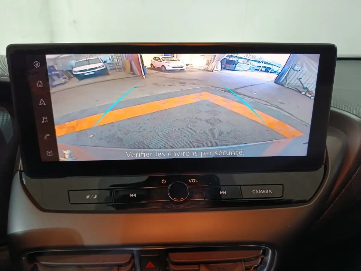 Écran tactile central du Nissan Juke 2025 affichant la caméra de recul avec guidage de trajectoire en bleu.