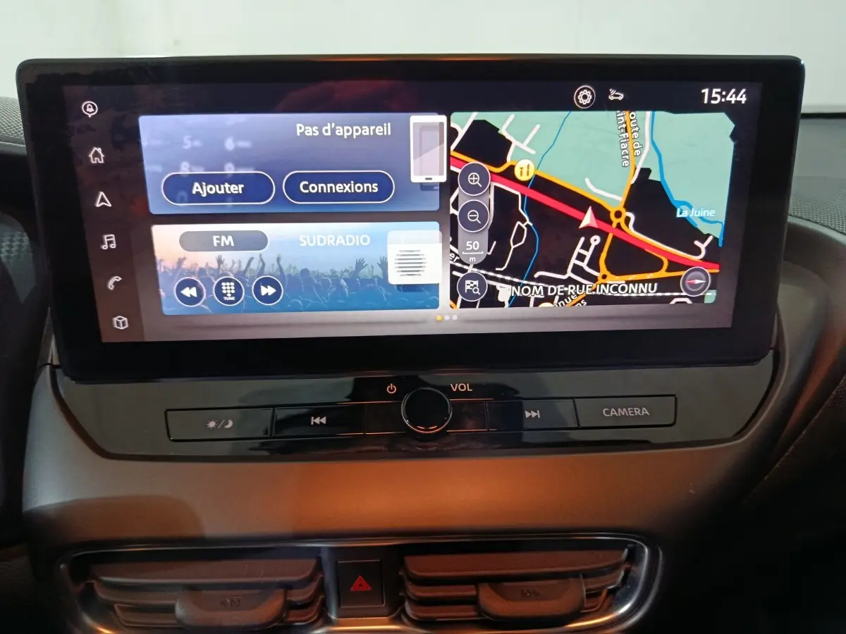Écran tactile central 12,3 pouces du tableau de bord du Nissan Juke 2025, affichant navigation et radio FM.