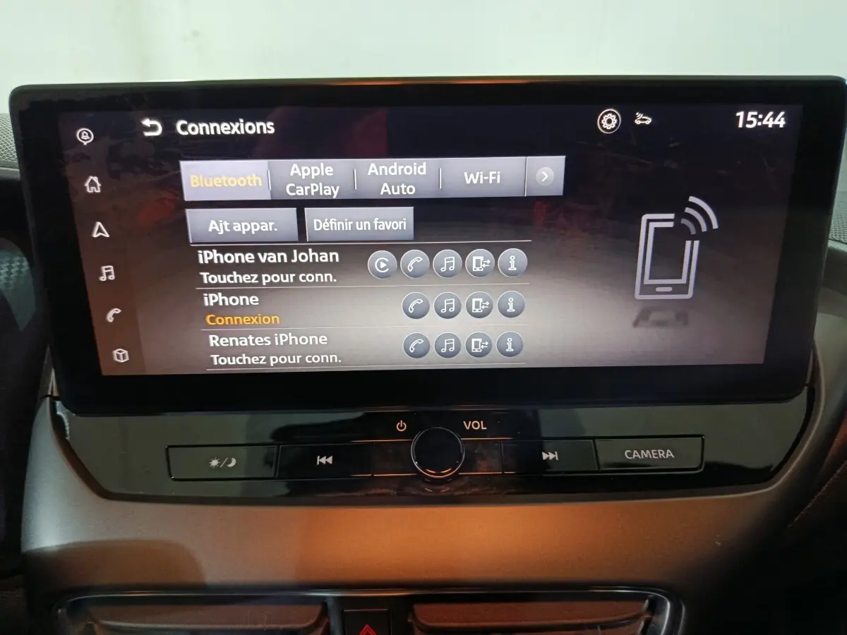 Écran tactile central du tableau de bord du Nissan Juke gris foncé, affichant les options de connexion Bluetooth et Apple CarPlay.