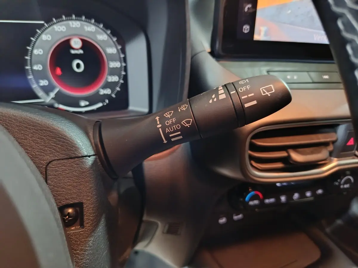 Gros plan sur la commande d’essuie-glace à gauche du volant dans l’habitacle gris foncé du Nissan Juke 2025.