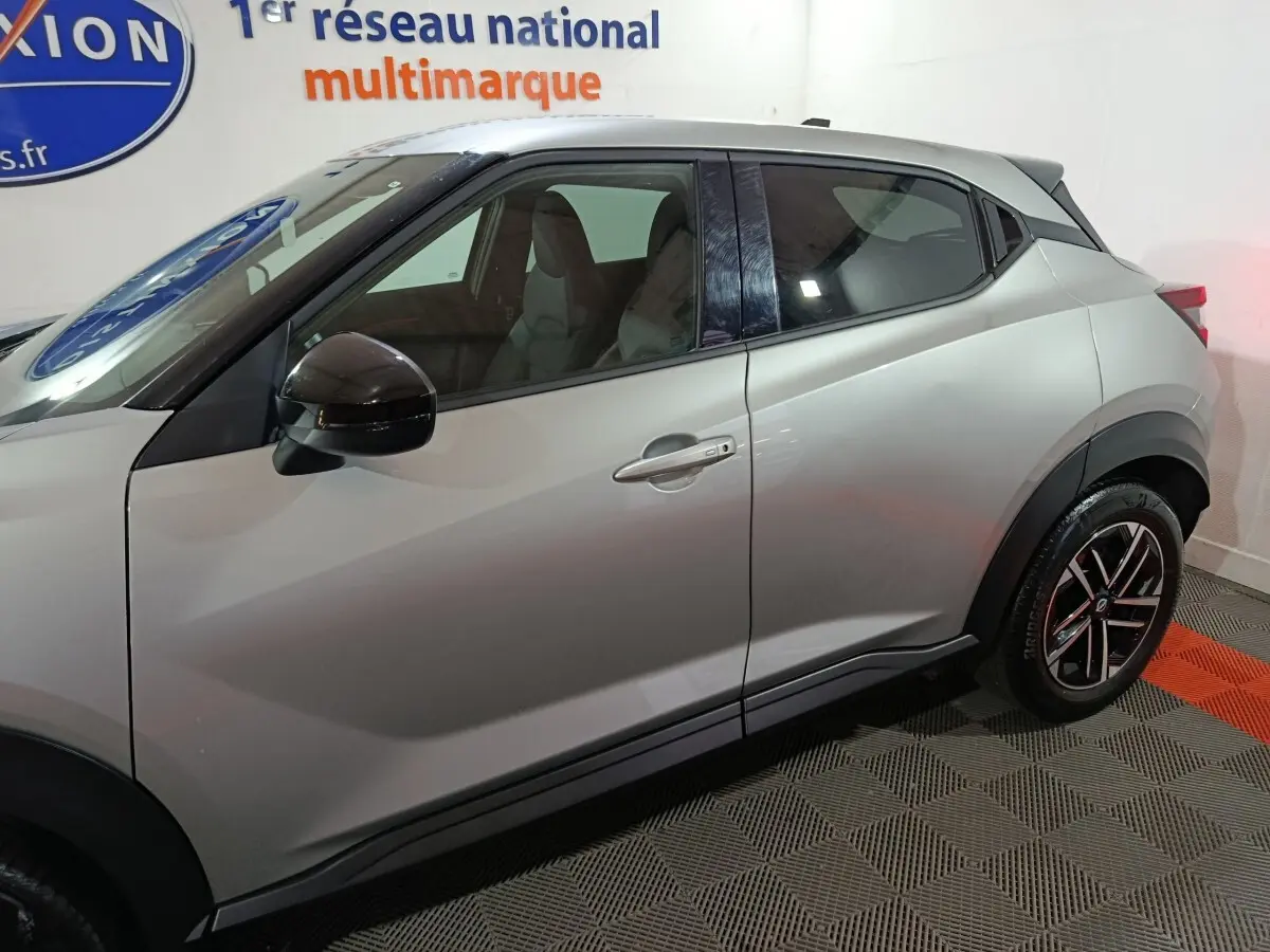 Vue de profil côté gauche du Nissan Juke gris foncé 2025, mettant en valeur ses lignes compactes et ses jantes noires.