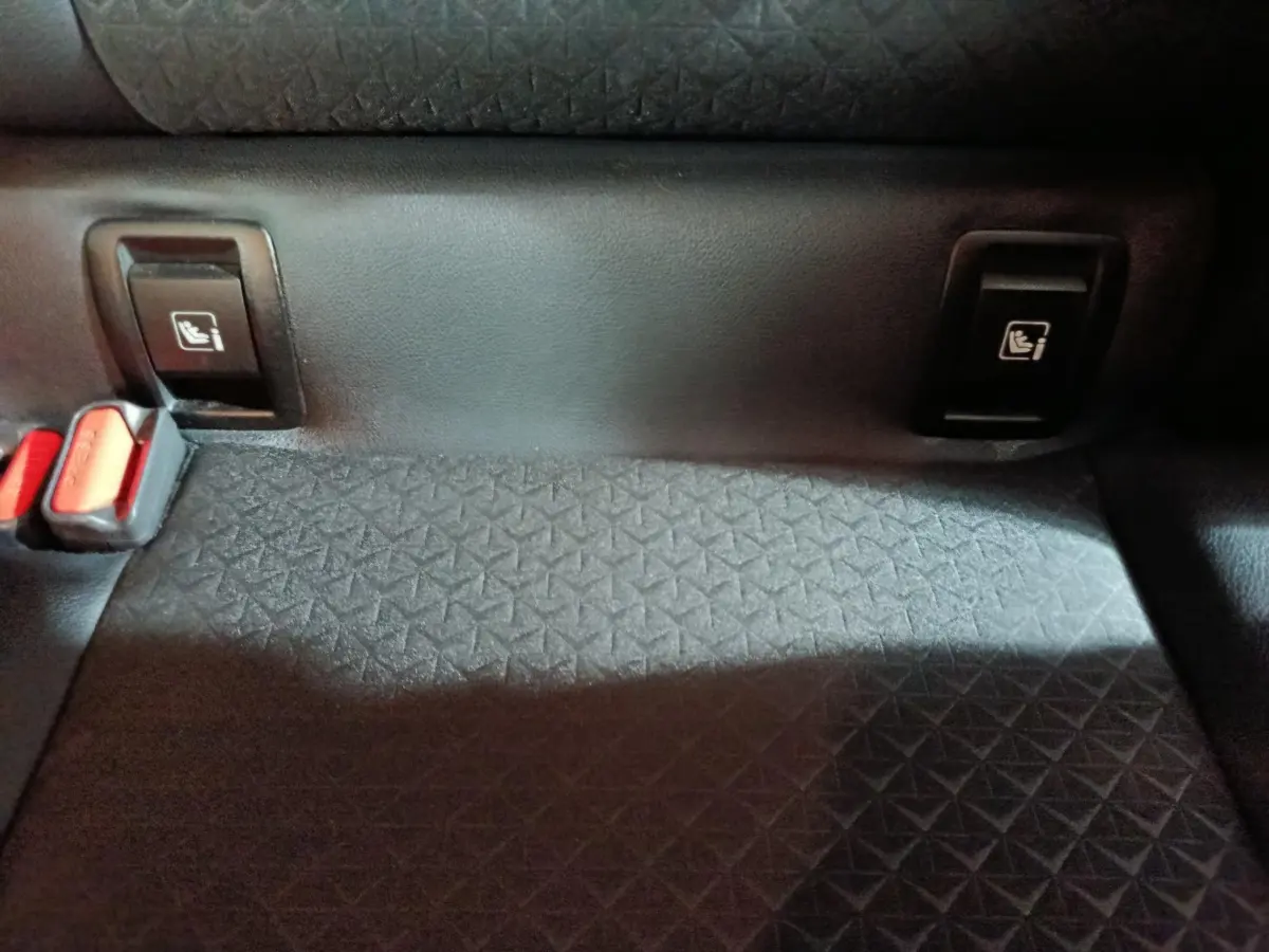 Détail de la banquette arrière noire du Nissan Juke 2025 avec attaches Isofix visibles de face.