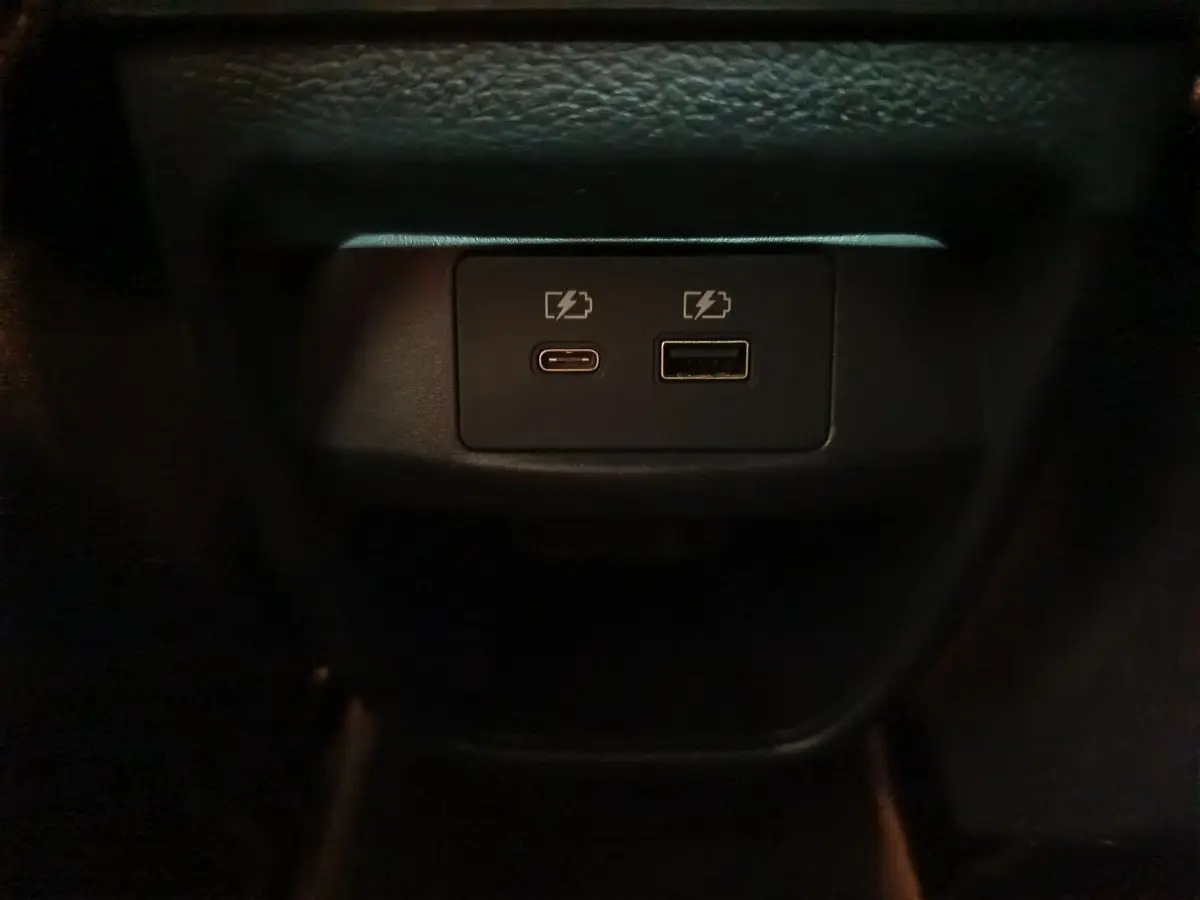 Gros plan sur les ports USB-C et USB-A pour recharge dans l'habitacle du Nissan Juke gris foncé 2025.