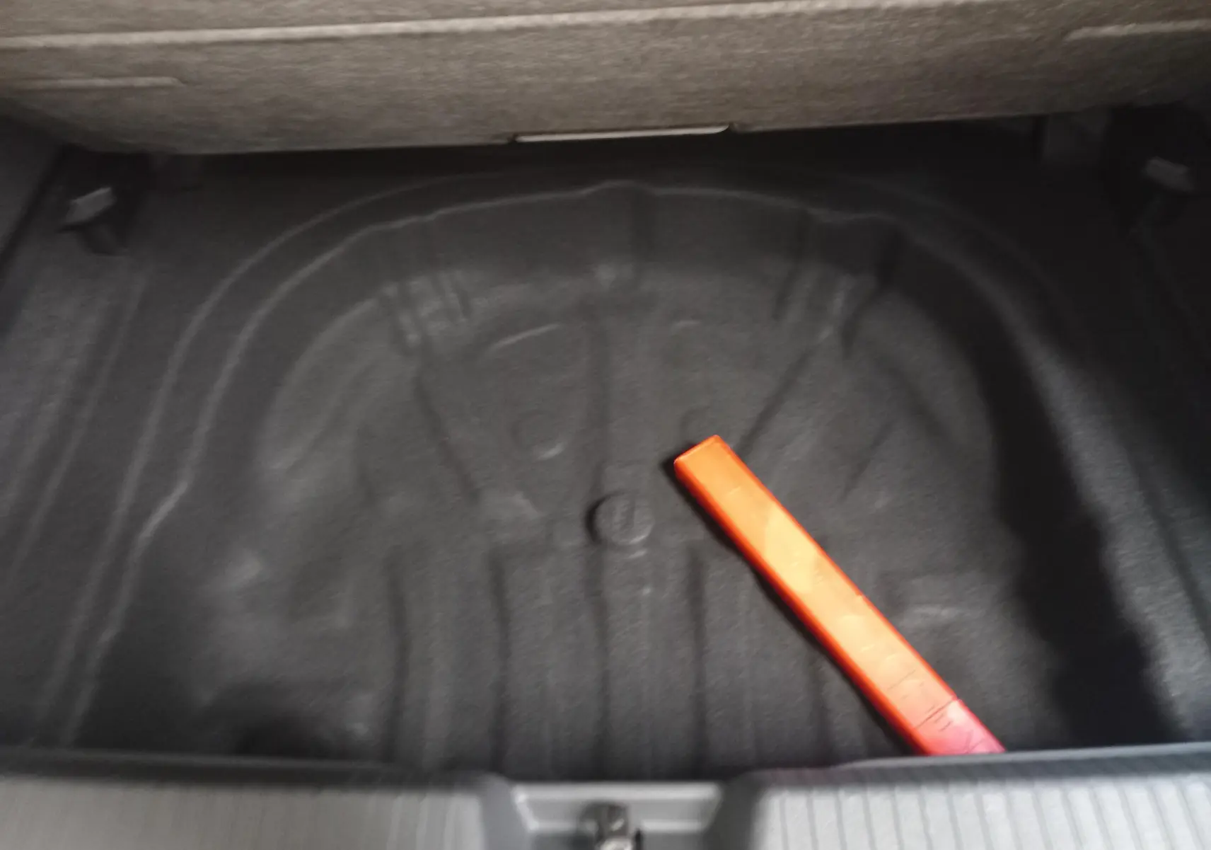 Coffre ouvert d’une Volkswagen Golf 1.5 eTSI 150 DSG7 R-Line Edition 2025, montrant l’espace de rangement noir avec triangle de signalisation.