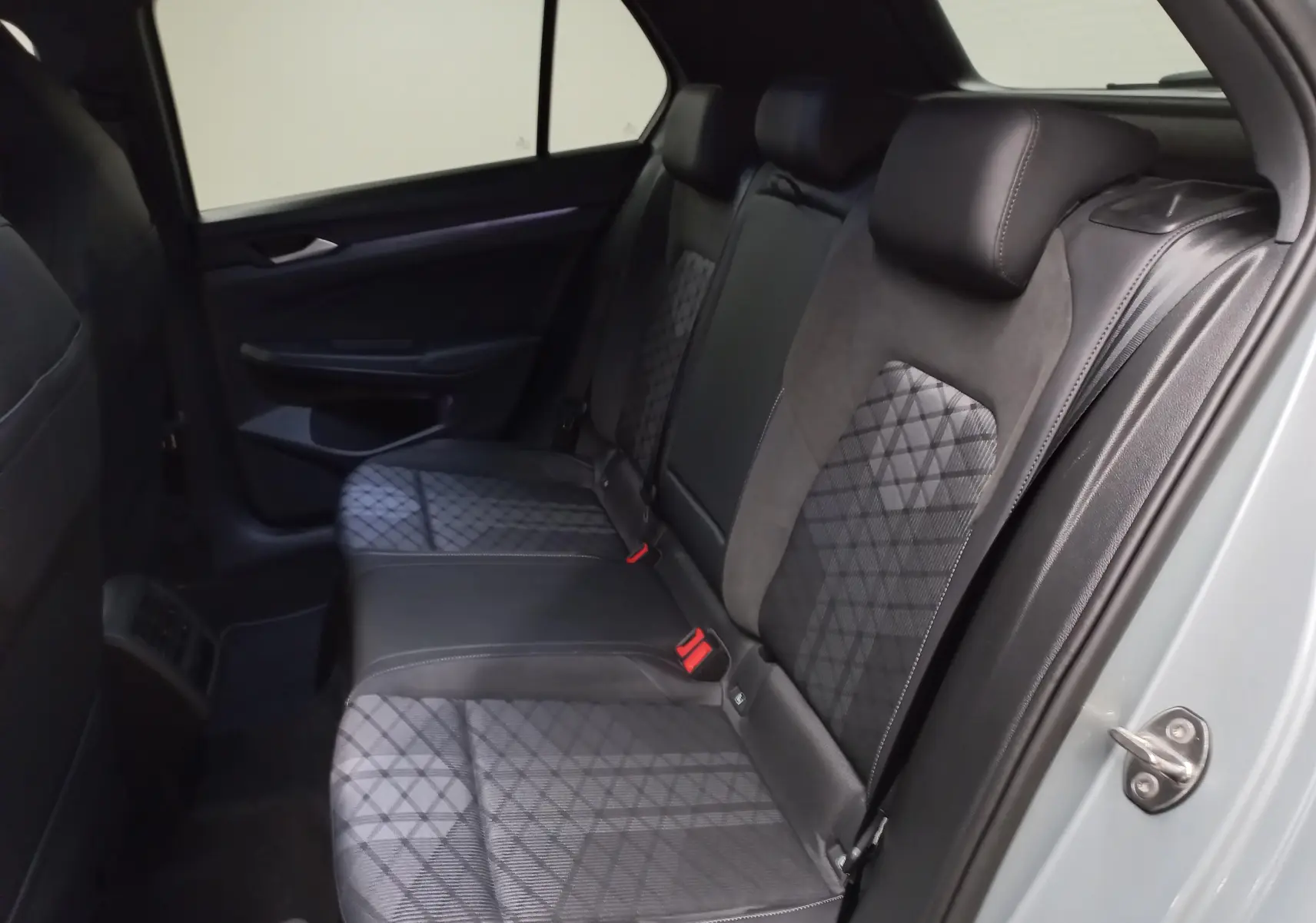 Vue intérieure côté droit des sièges arrière en tissu et cuir noir de la Volkswagen Golf 1.5 eTSI R-Line argent dolomite.