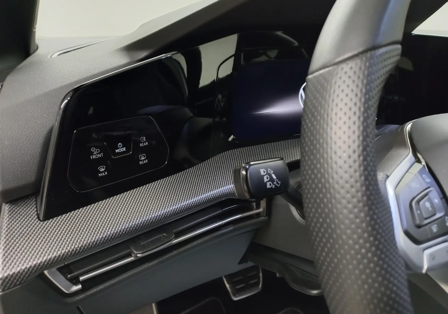 Vue intérieure du tableau de bord de la Volkswagen Golf 1.5 eTSI 150 DSG7 R-Line Edition avec volant perforé et commandes digitales.