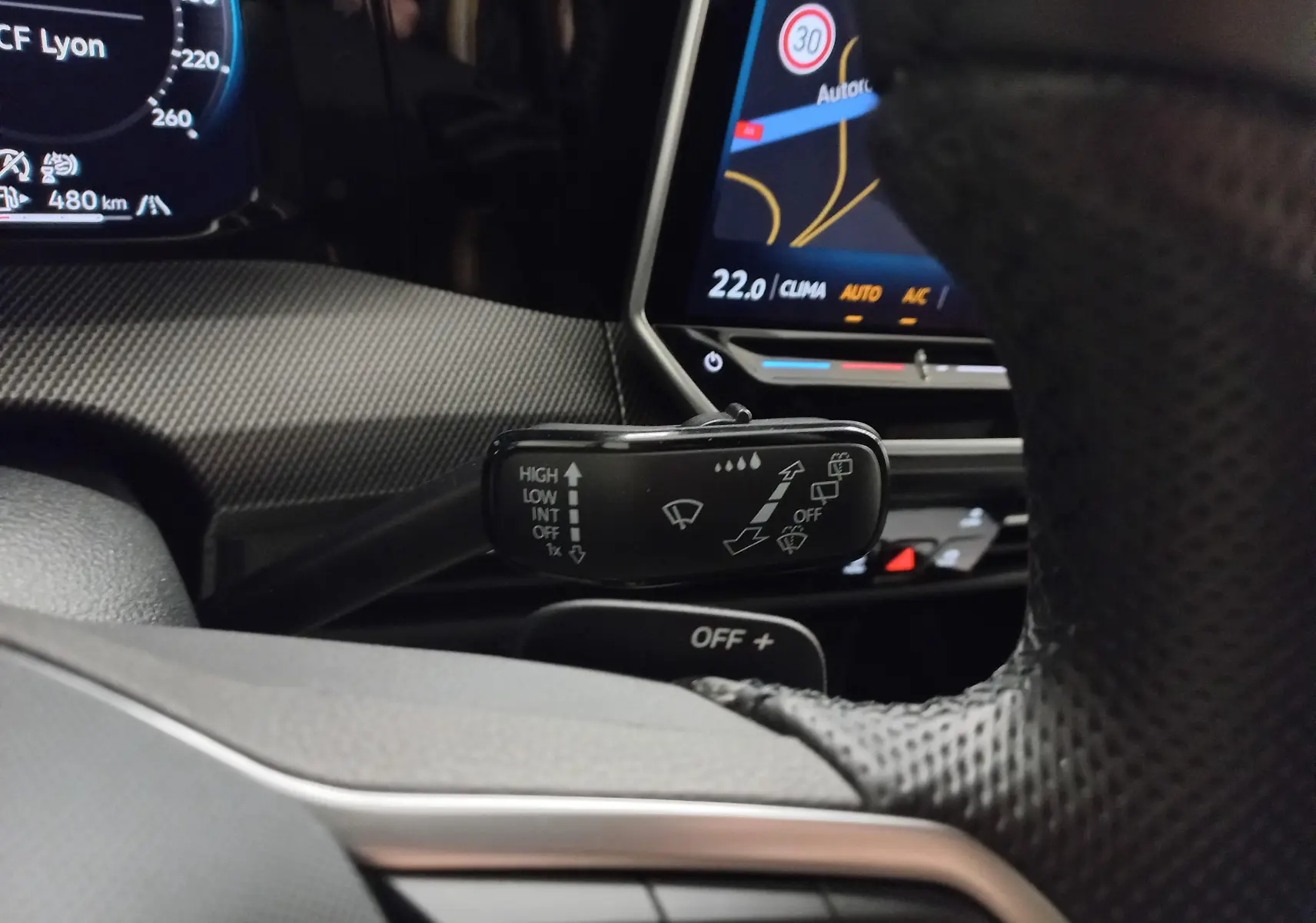 Vue rapprochée du commodo d’essuie-glace dans l’habitacle d’une Volkswagen Golf 1.5 eTSI argent dolomite, tableau de bord numérique visible.