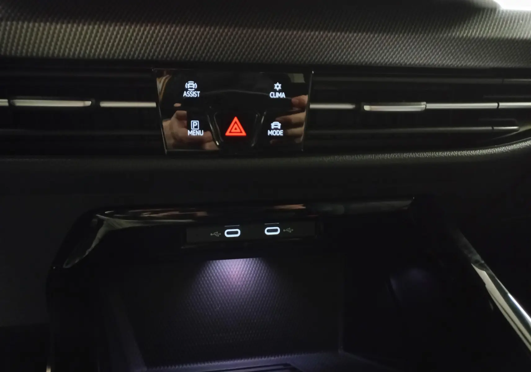 Vue rapprochée du tableau de bord noir de la Volkswagen Golf 1.5 eTSI 150 DSG7 R-Line Edition avec commandes tactiles éclairées.