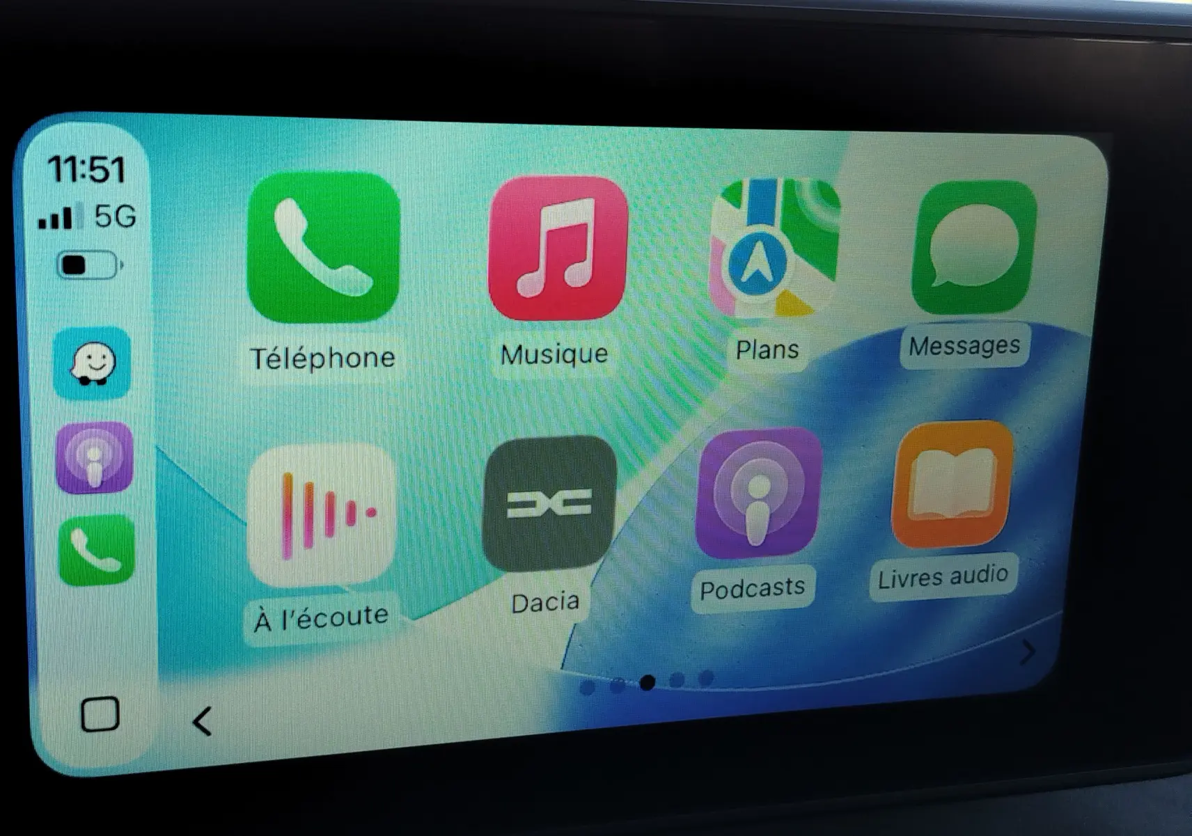 Écran tactile intérieur du Dacia Jogger montrant l'interface Apple CarPlay avec icônes colorées sur fond clair.