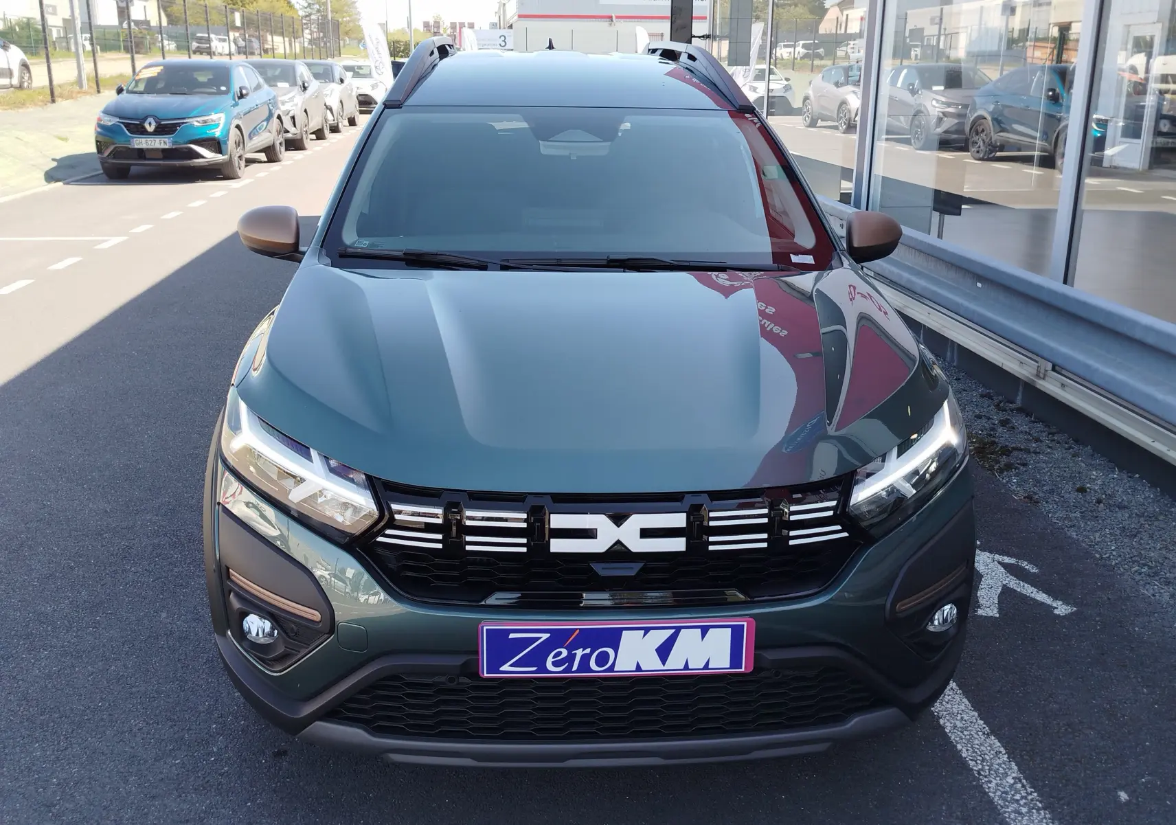 Vue avant d'une Dacia Jogger 1.0 ECO-G 100CH EXTREME 7PL vert cèdre métal avec calandre noire et feux LED allumés.