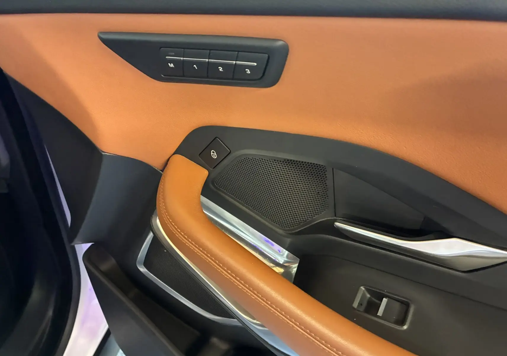 Détail de la porte avant gauche du Jaguar E-PACE 2019, cuir brun et commandes mémoire des sièges visibles.