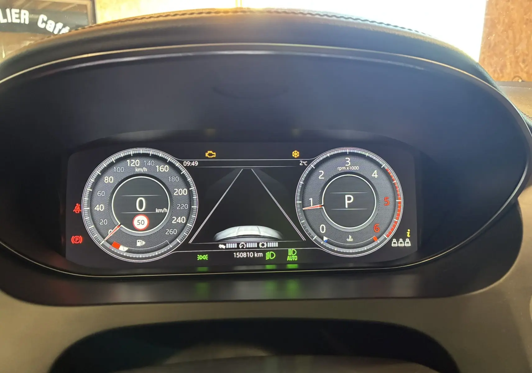 Tableau de bord numérique du Jaguar E-PACE blanc 2019, affichant vitesse, régime moteur et indicateurs de conduite.