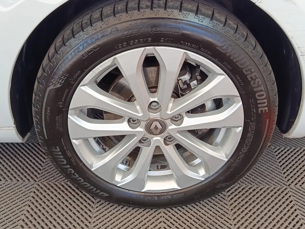 Gros plan sur la roue avant droite blanche d'une Renault ZOE Zen R135 2021 avec jante alliage et pneu Bridgestone.