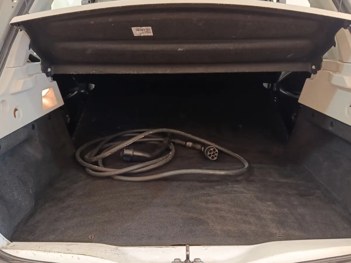 Coffre ouvert d’une Renault ZOE blanche 2021, avec câble de recharge électrique visible à l’intérieur.