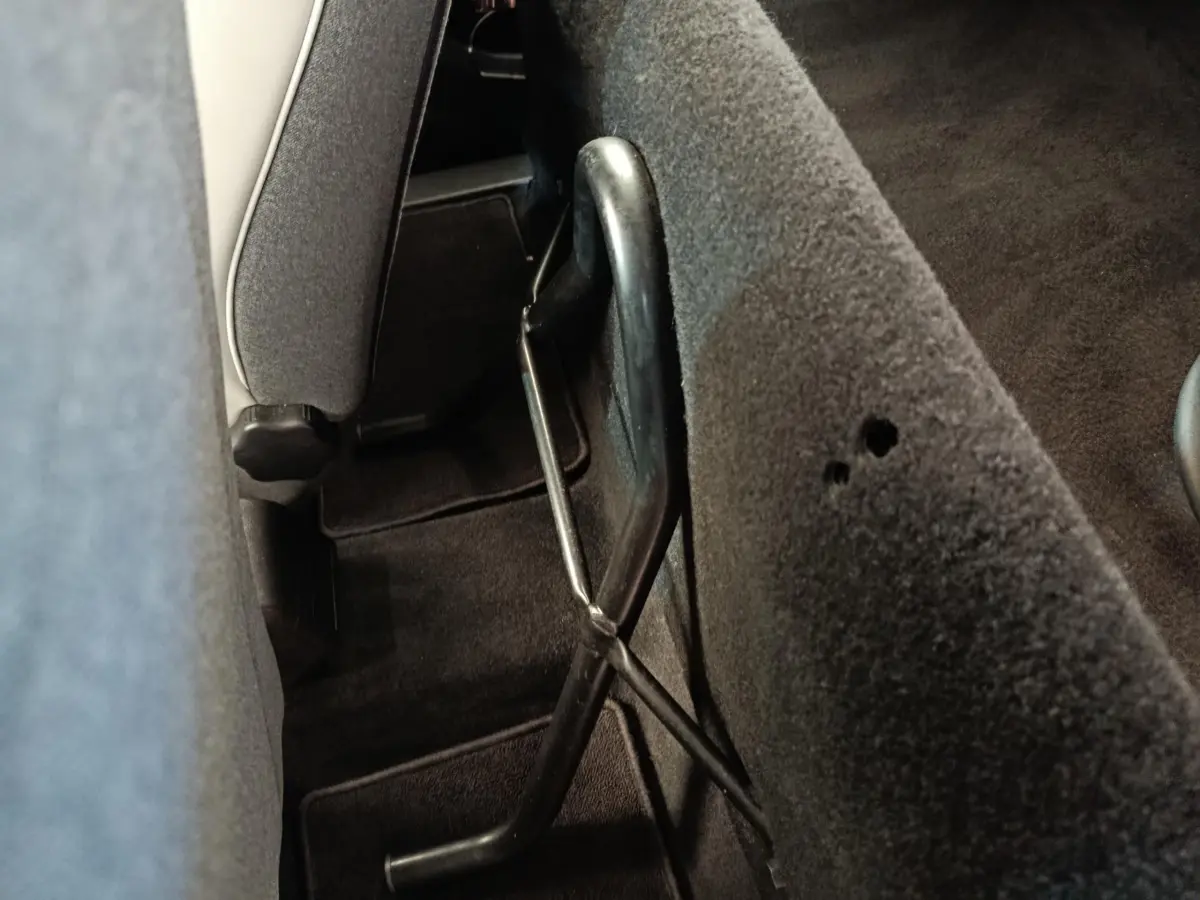 Détail de la banquette arrière rabattue avec mécanisme de levage visible dans l’habitacle d’une Renault ZOE blanche.