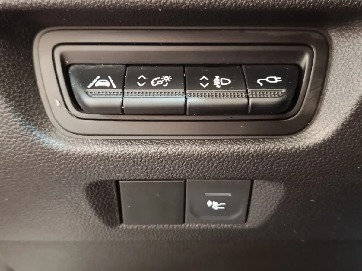 Gros plan sur les boutons de commande noirs du tableau de bord de la Renault ZOE blanche, version Zen R135.