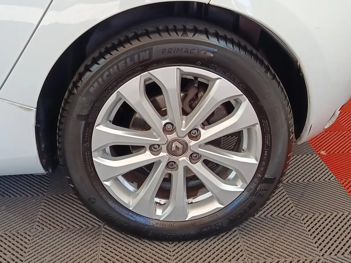 Gros plan sur la roue avant gauche blanche d’une Renault ZOE Zen R135 avec jante alliage et pneu Michelin.