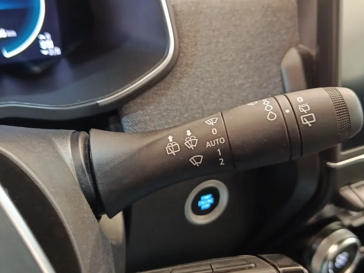 Gros plan sur la commande d’essuie-glace à gauche du volant dans l’habitacle blanc de la Renault ZOE Zen R135 2021.