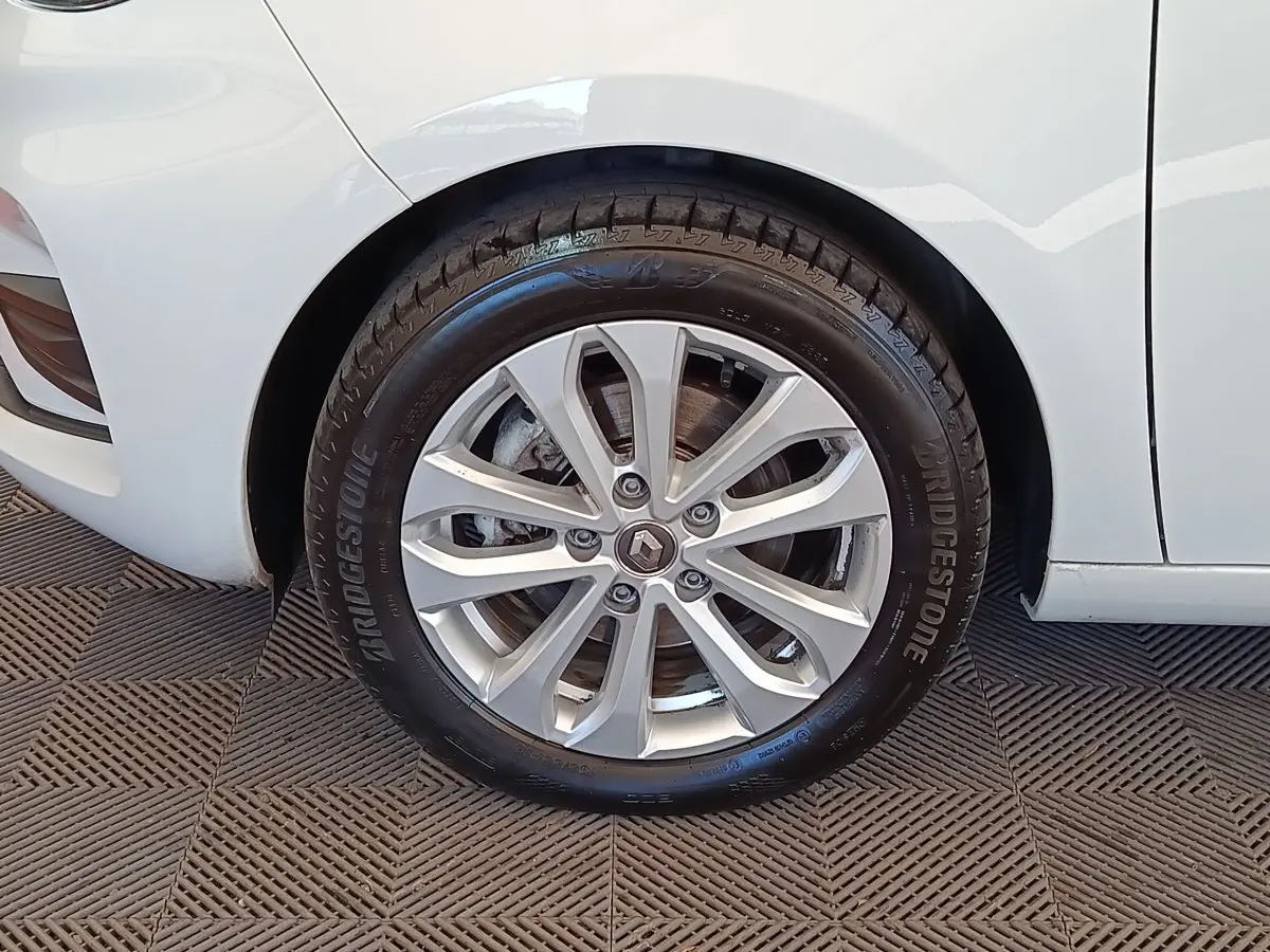 Gros plan sur la roue arrière droite de la Renault ZOE blanche, avec jante alliage et pneu Bridgestone visible.