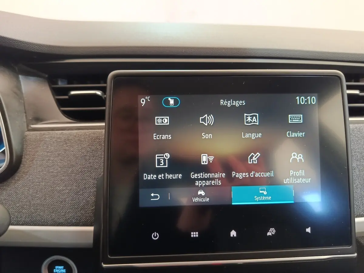 Écran tactile central affichant le menu réglages dans l’habitacle d’une Renault ZOE blanche de 2021.